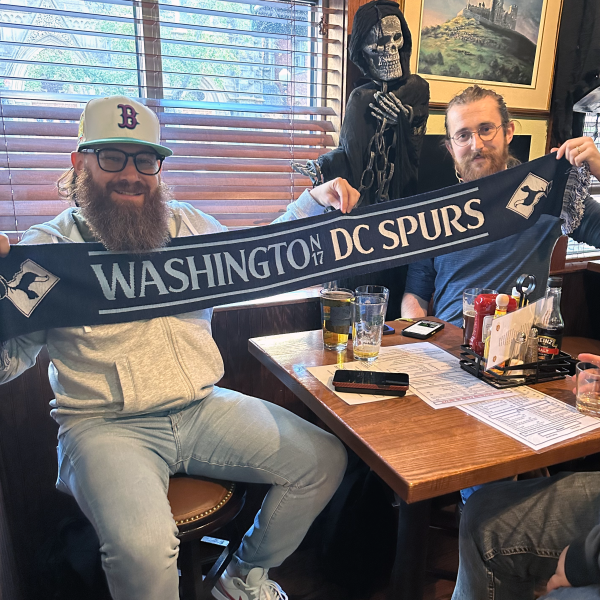 Two men holding the DC Spurs scarf in a bar